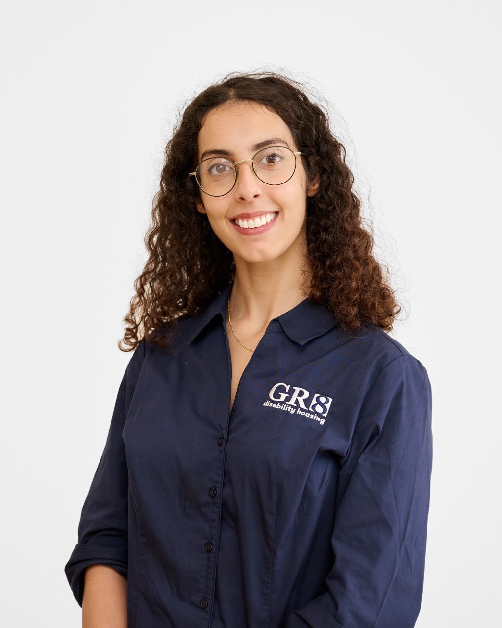 A woman in a blue shirt is smiling for the camera.