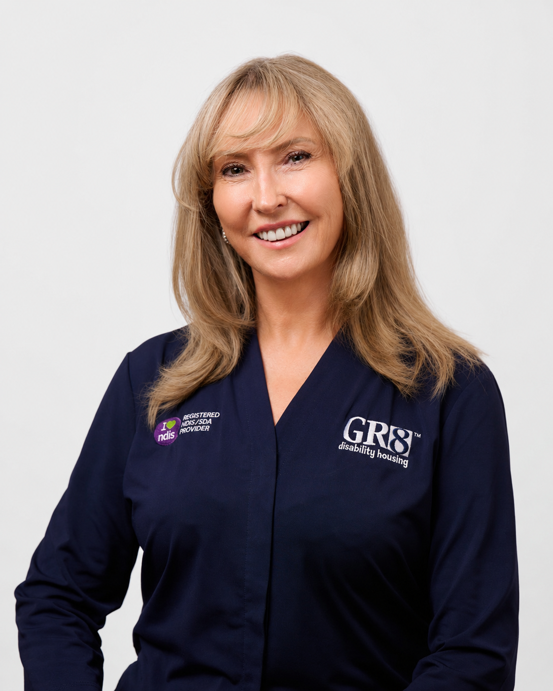 Woman in a navy shirt smiling against a light background