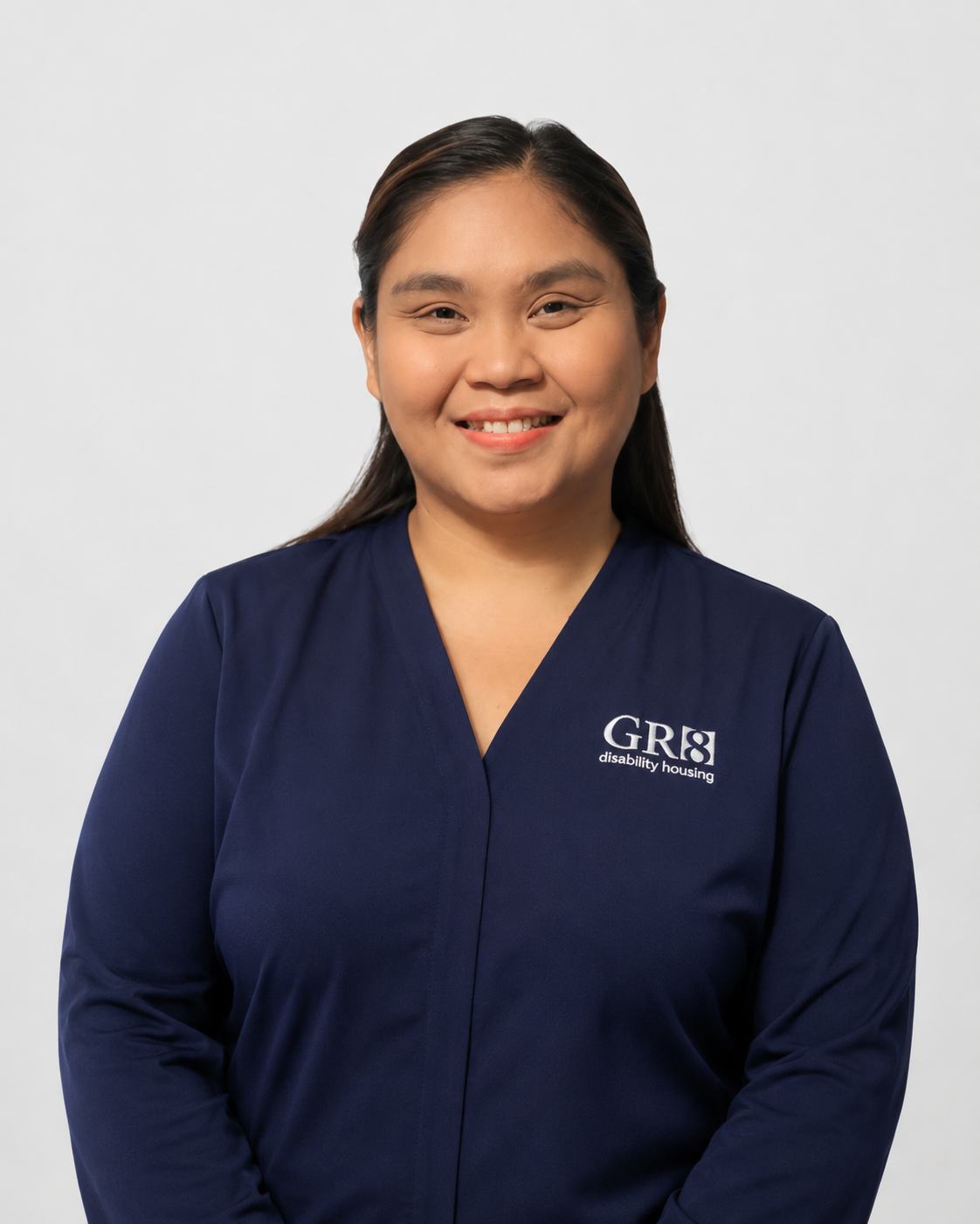 Woman in a navy blue top smiling in a studio portrait.