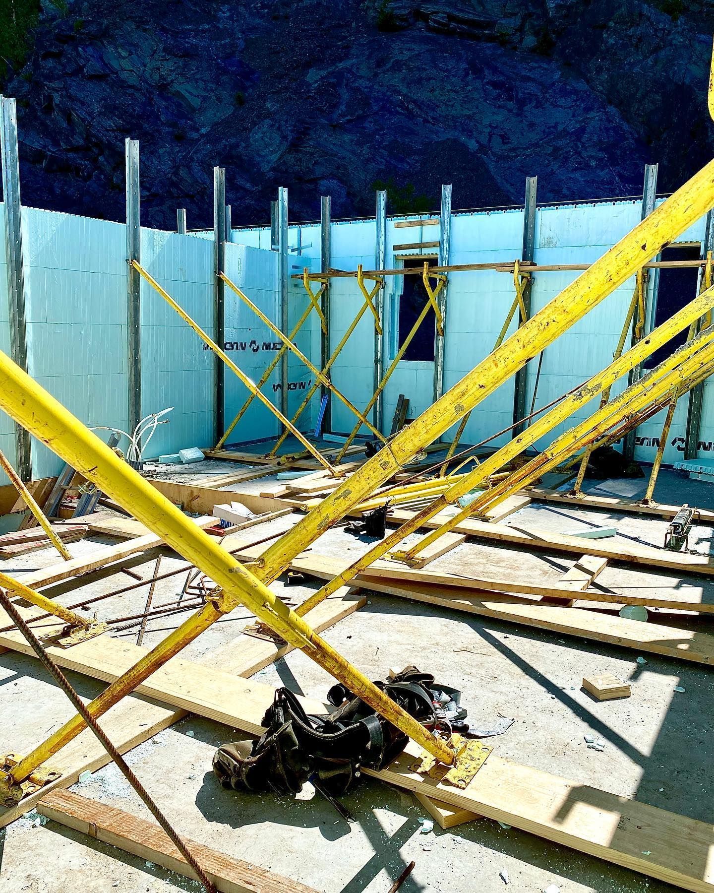 Construction site with yellow scaffolding, foam walls, and wooden planks.