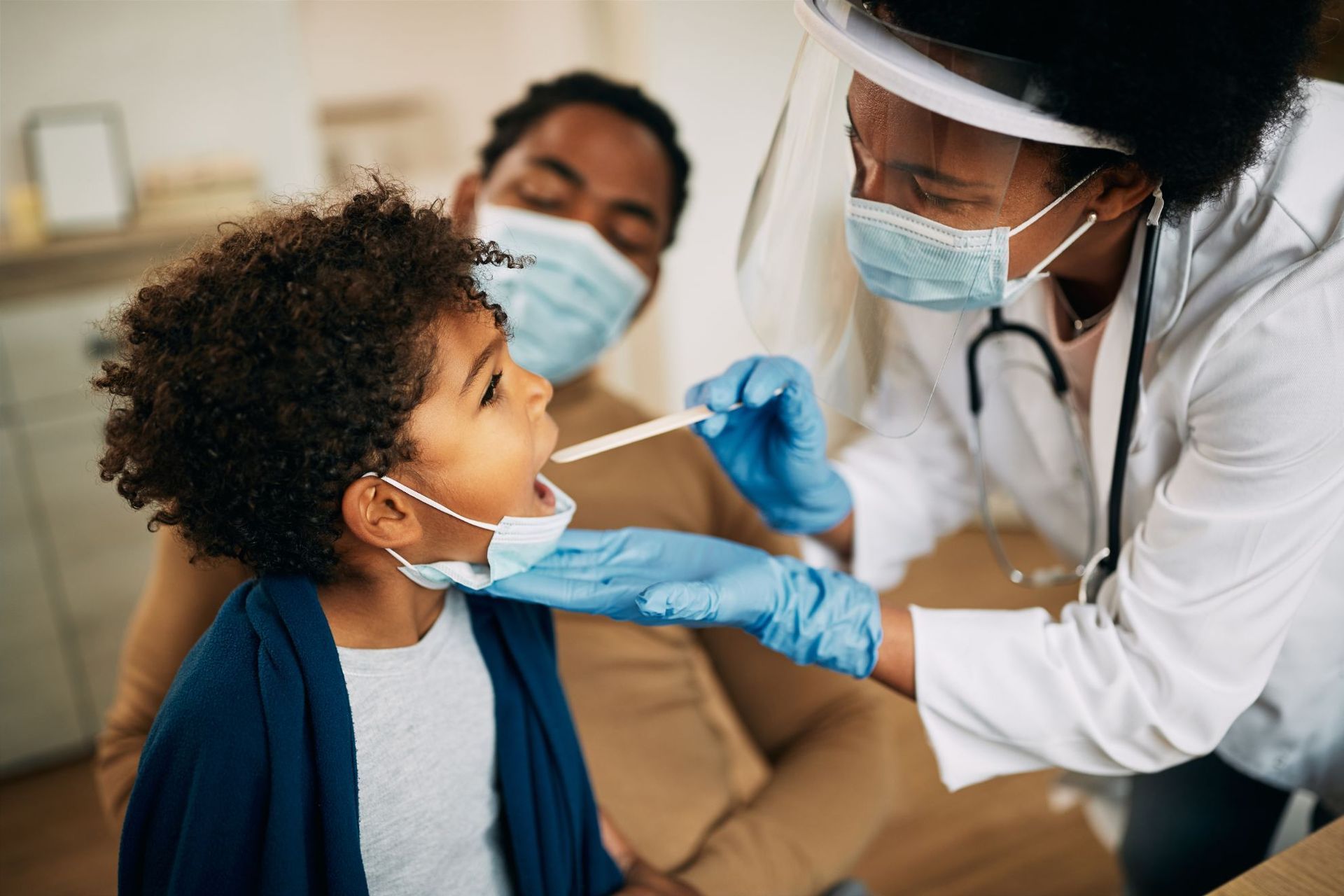 A doctor is taking a sample from a child 's throat.