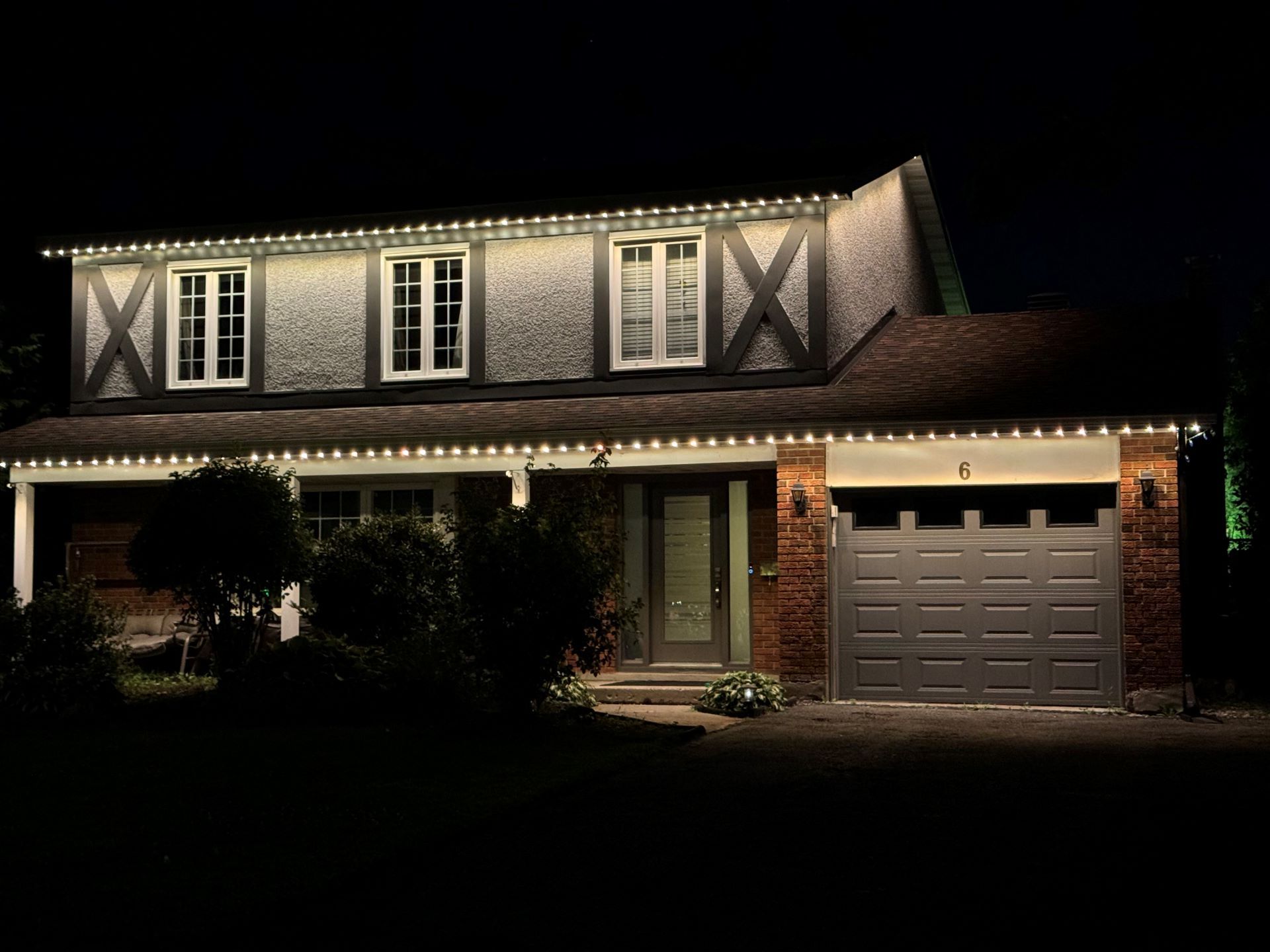 Warm white permanent roofline lighting installed on a Tampa Bay two-story home