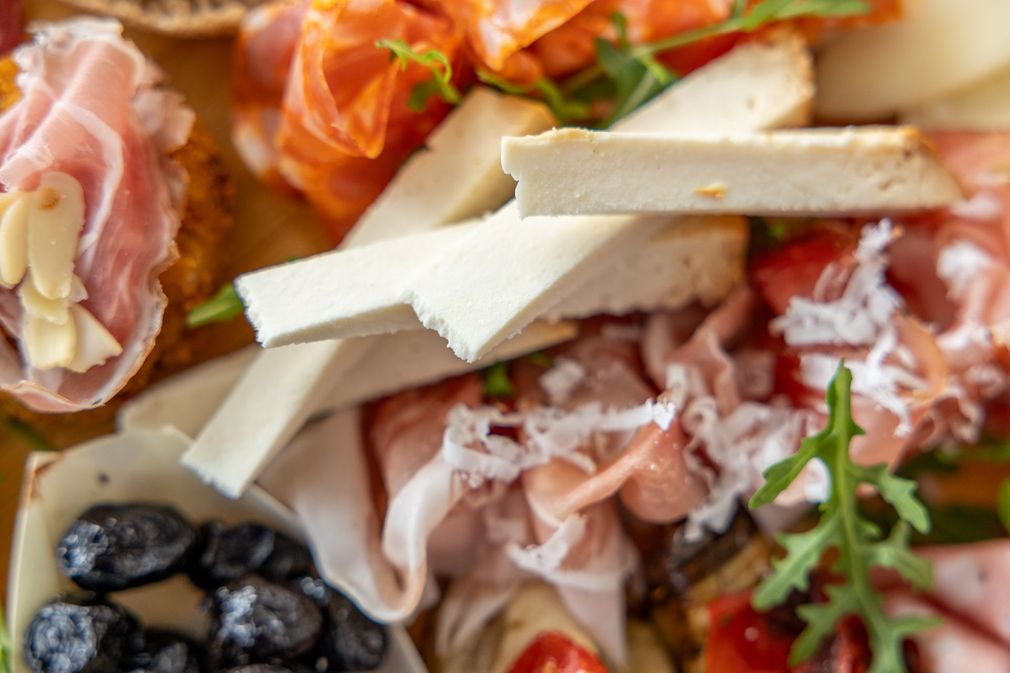 Assortimento di salumi con affettati, formaggi, olive e verdure su un piatto