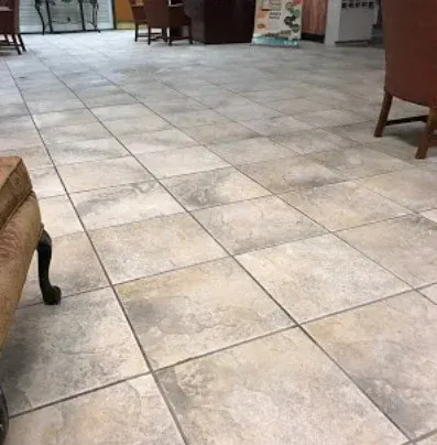Indoor lobby with light tiled floor and a few chairs along the edges