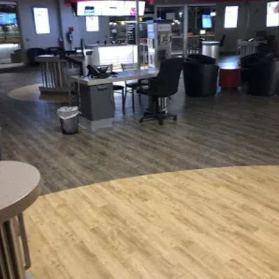 Empty modern café or casino counter area with chairs, tables, and bright screens in the background