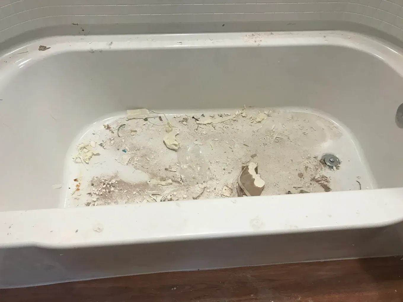Dirty white sink basin with scattered debris and stains