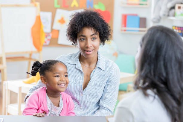 Woman and child smiling during a conversation in a bright classroom setting