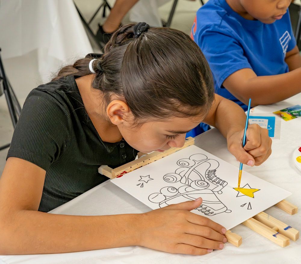 Children coloring at a table with crayons and a dinosaur worksheet