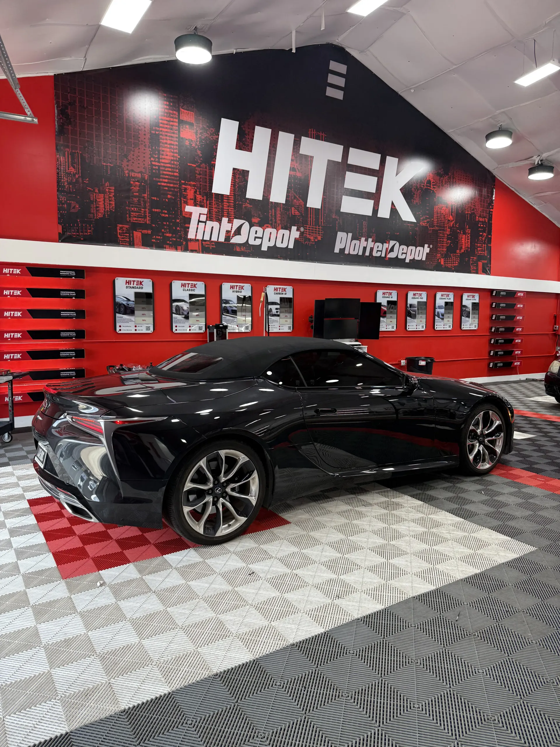Black convertible Lexus inside a shop with 