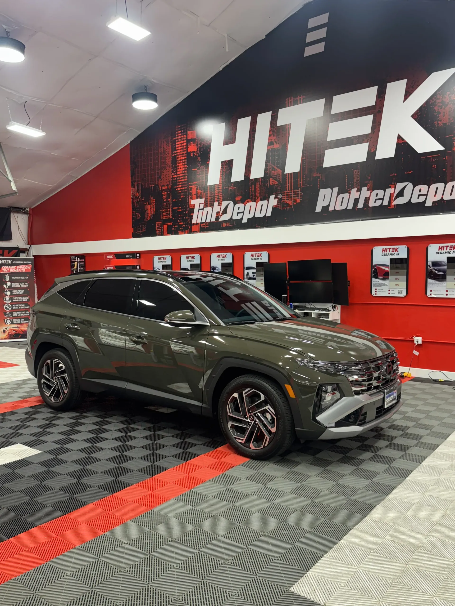Olive green Hyundai Tucson SUV inside a shop with 