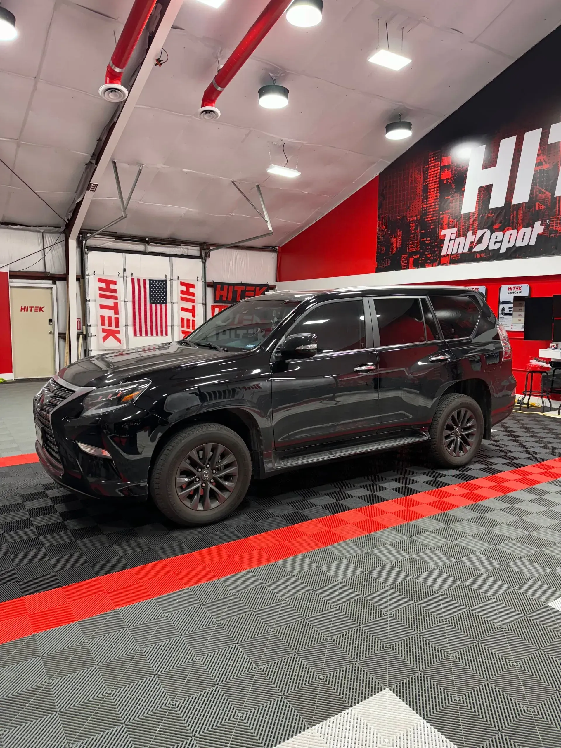 Black Lexus SUV in a garage with red and black accents.