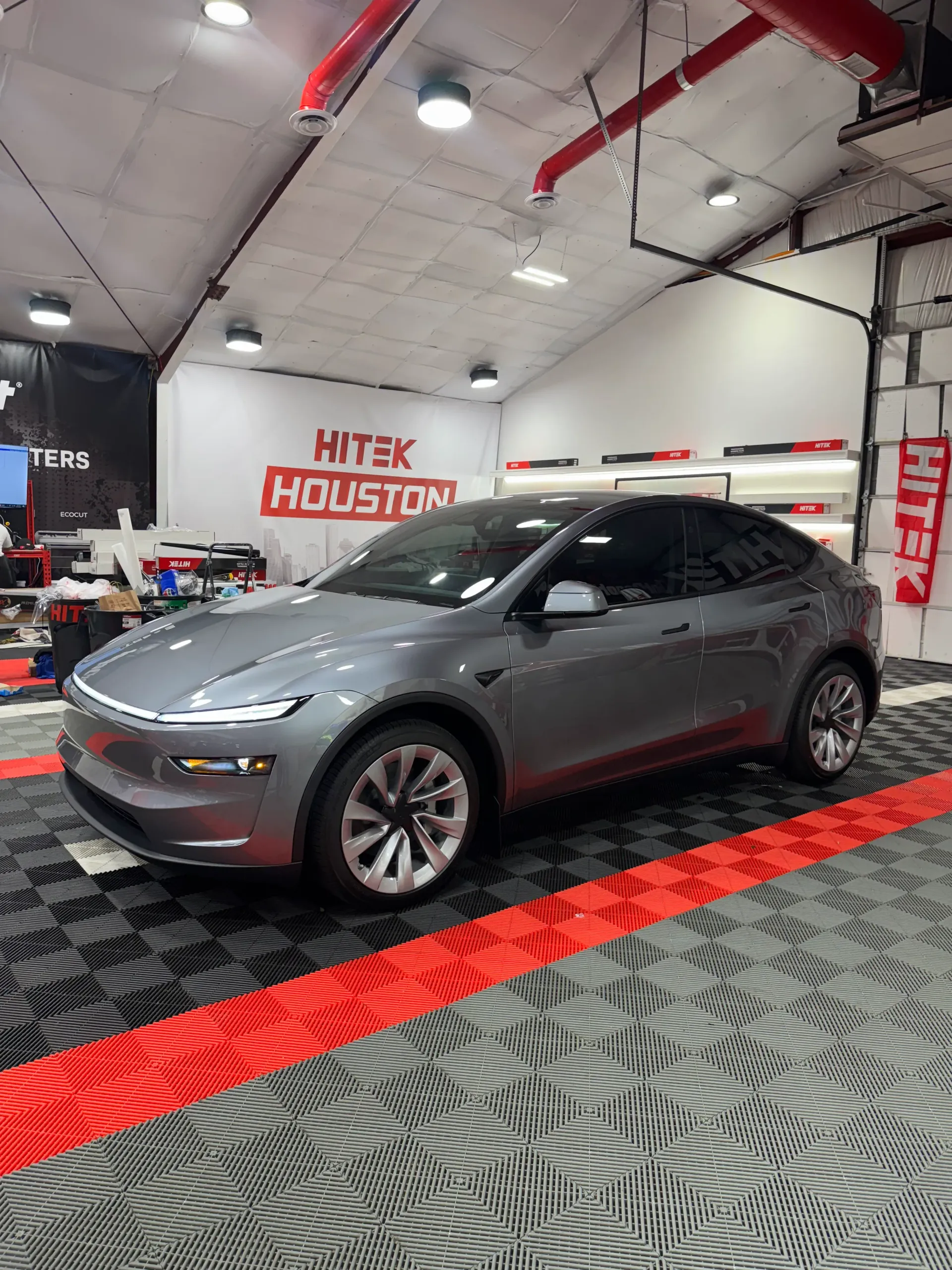 Gray Tesla electric car inside a garage with 