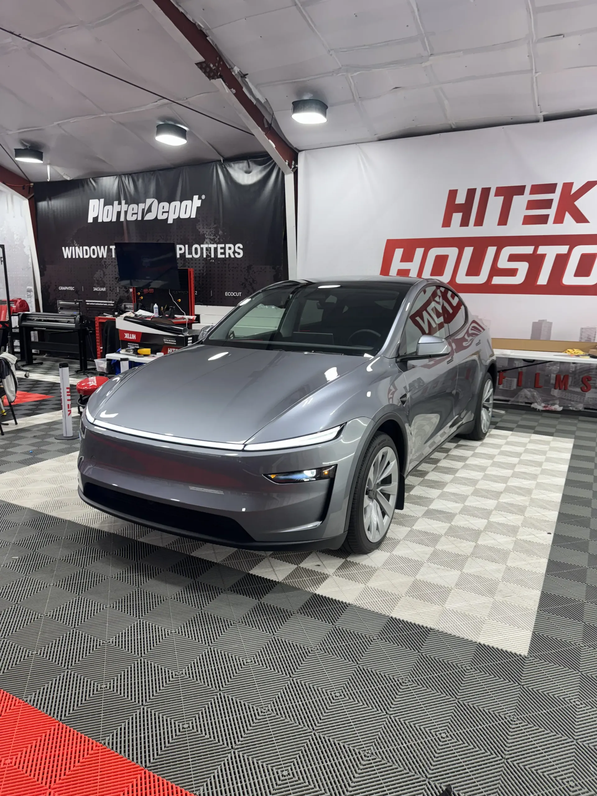 Gray electric car parked inside a facility. 