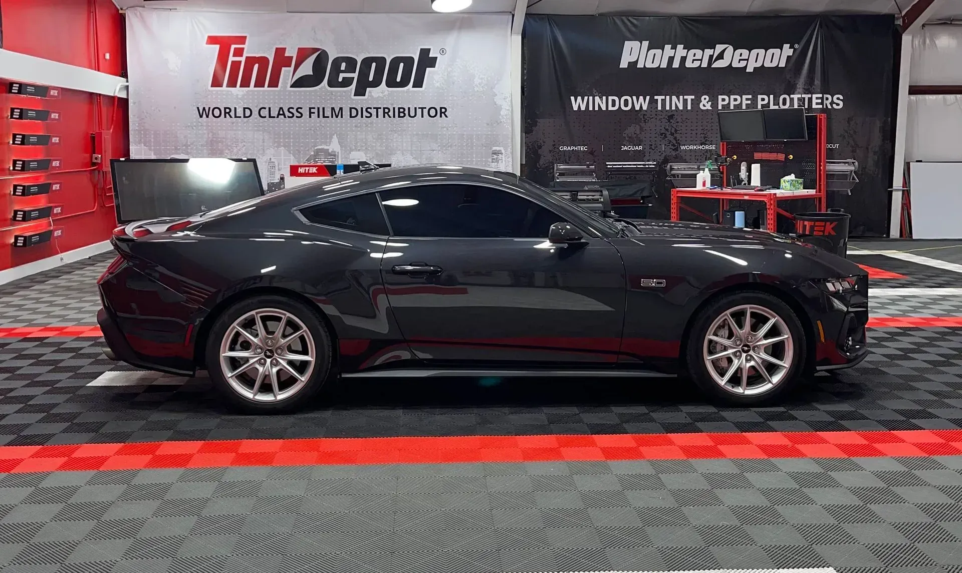 Dark gray Mustang with tinted windows inside the Tint Depot.