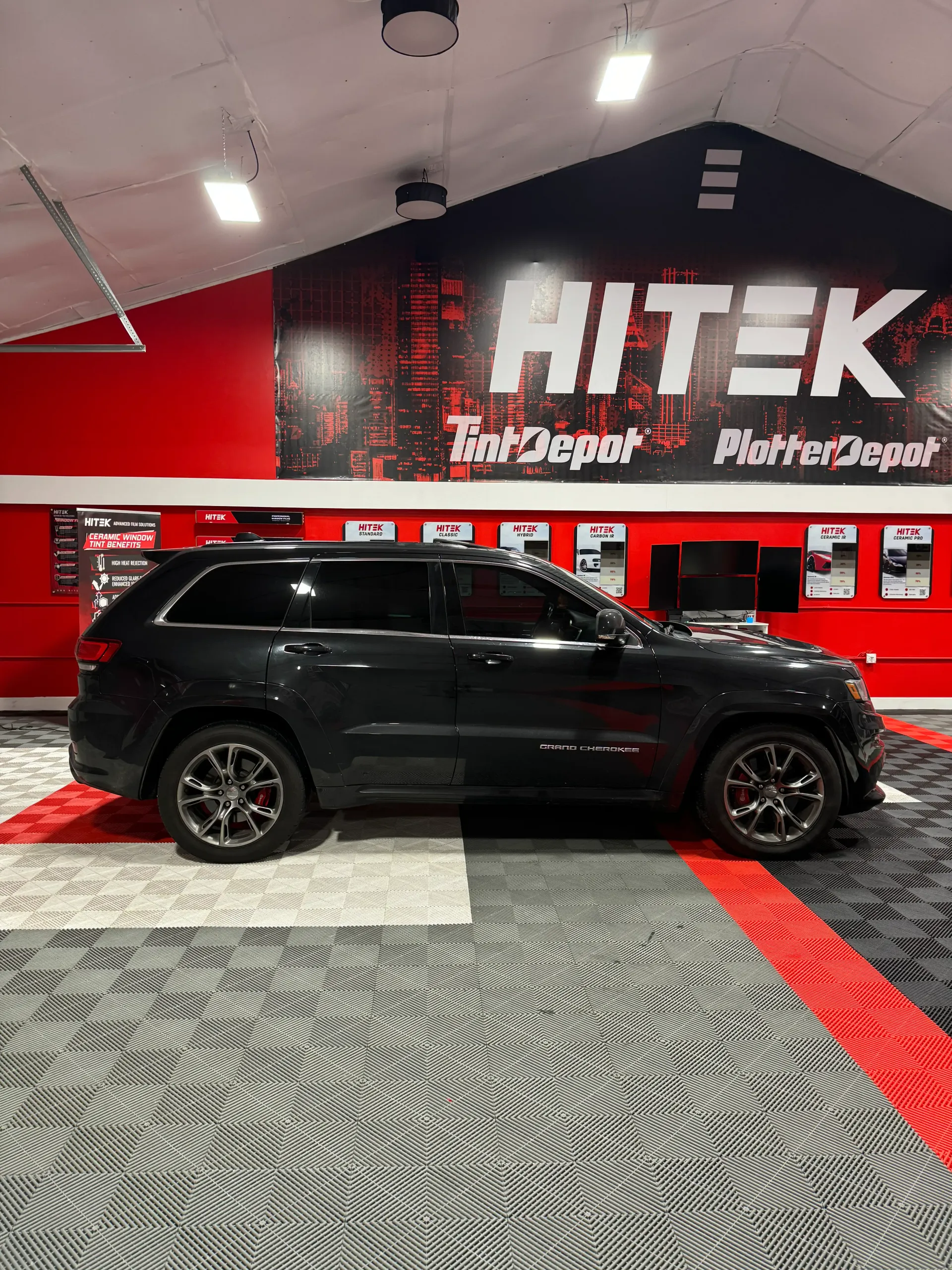 Black Jeep Grand Cherokee inside a shop with 