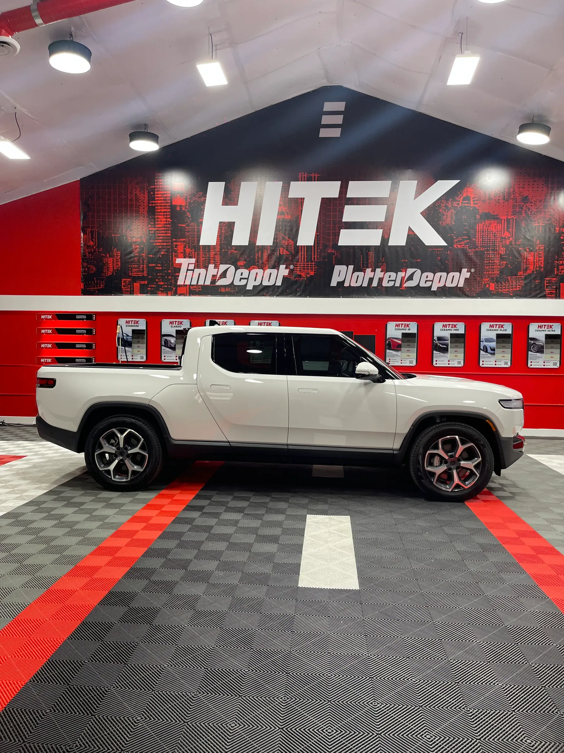 White Rivian truck parked inside a shop with 