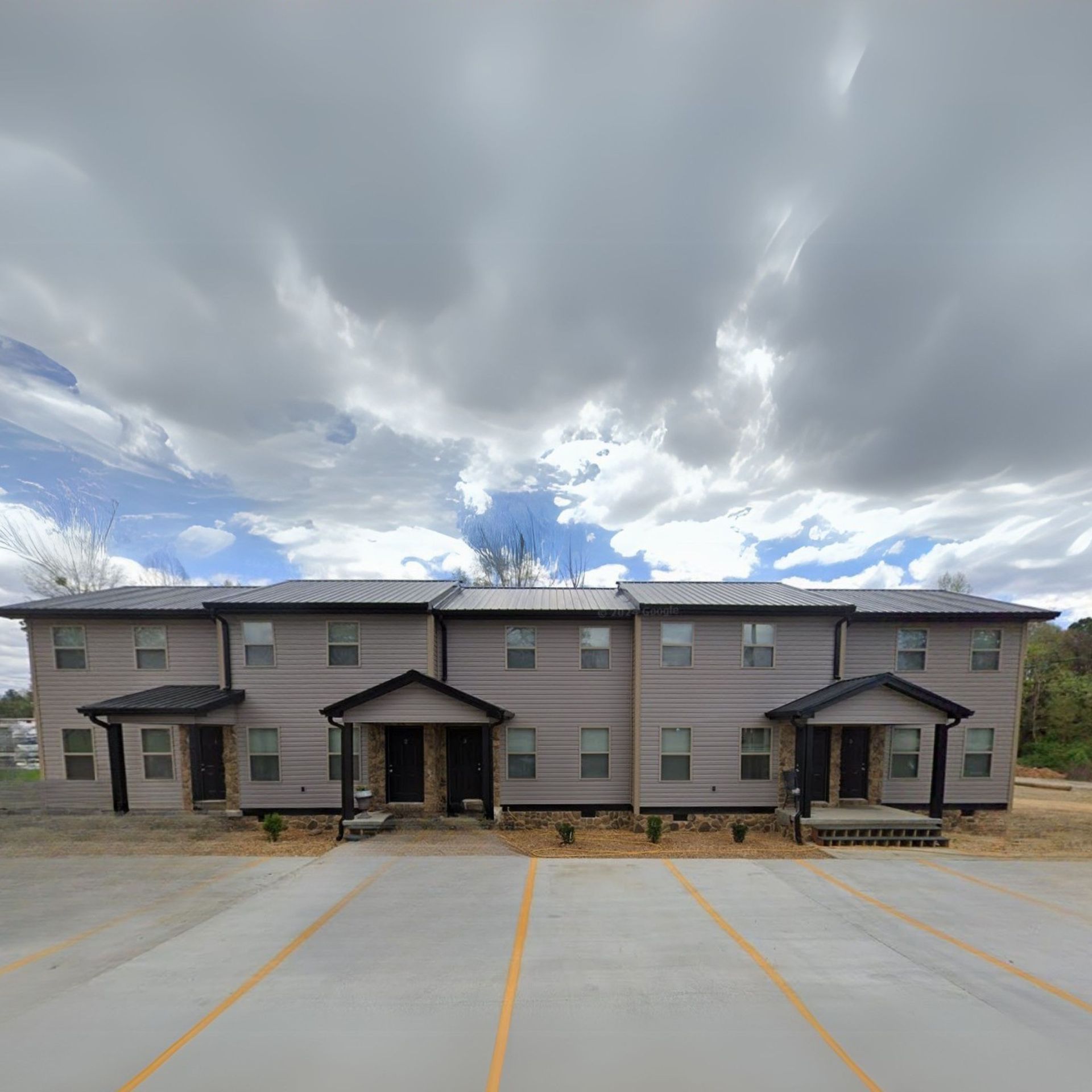 A large apartment building with a parking lot in front of it