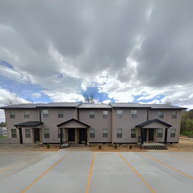 A large apartment building with a parking lot in front of it