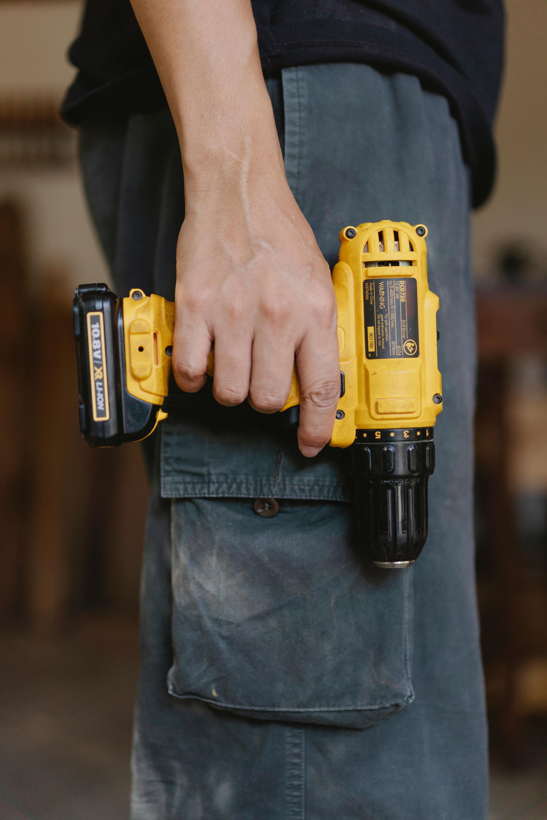 A man is holding a drill in his hand.