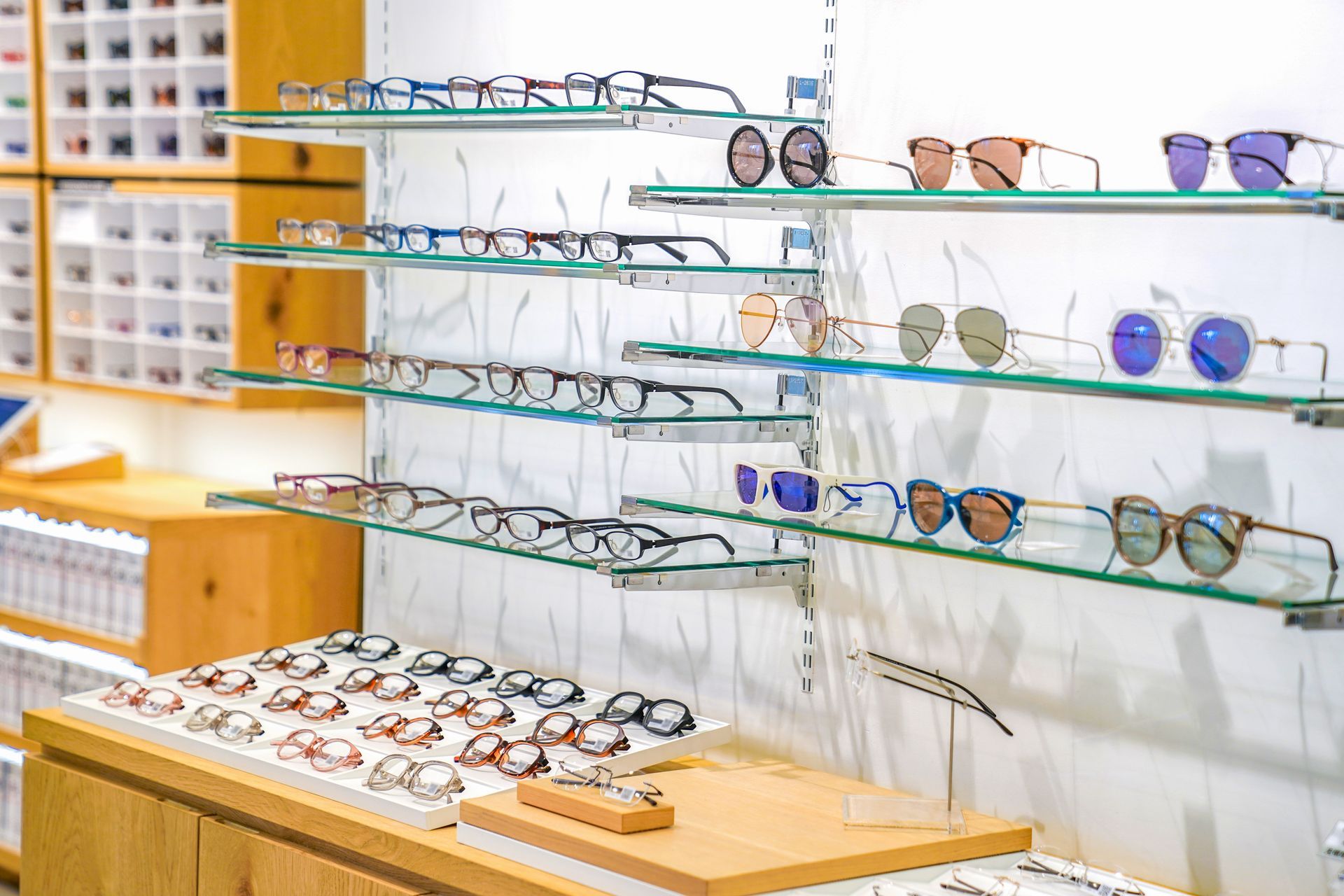 Eyeglass display shelves with assorted frames in a bright optical shop