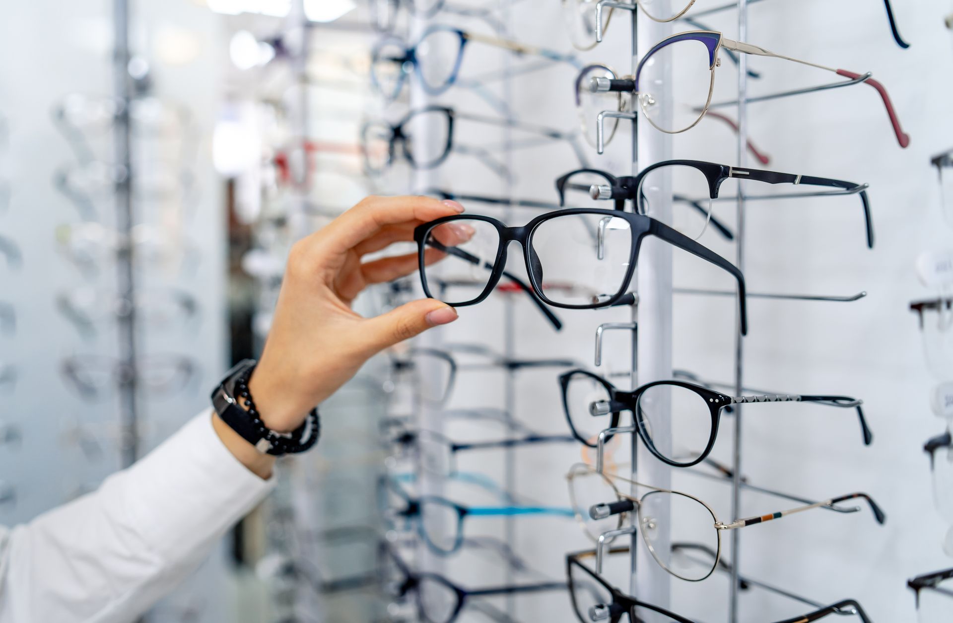 Assorted eyeglasses in various frame colors arranged on a white surface. Assorted eyeglasses in various frame colors arranged on a white surface.
