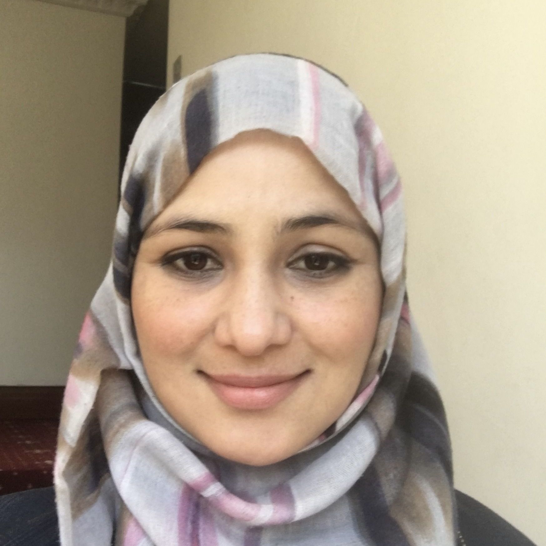 A woman wearing a hijab is smiling for the camera
