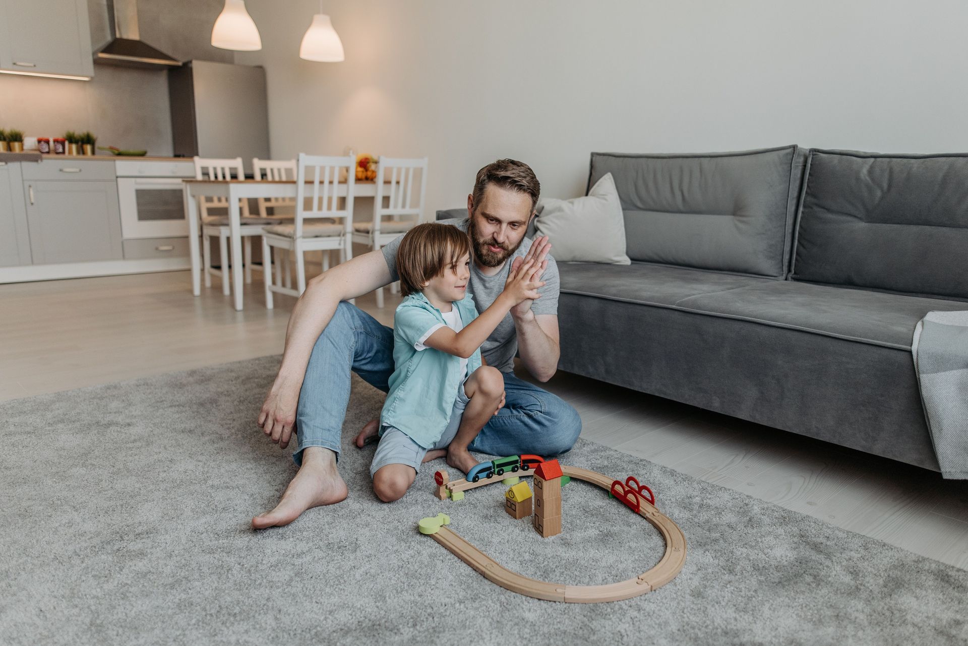 Wooden toy blocks and a soft cotton blanket arranged on a neutral surface, evoking play-based connection