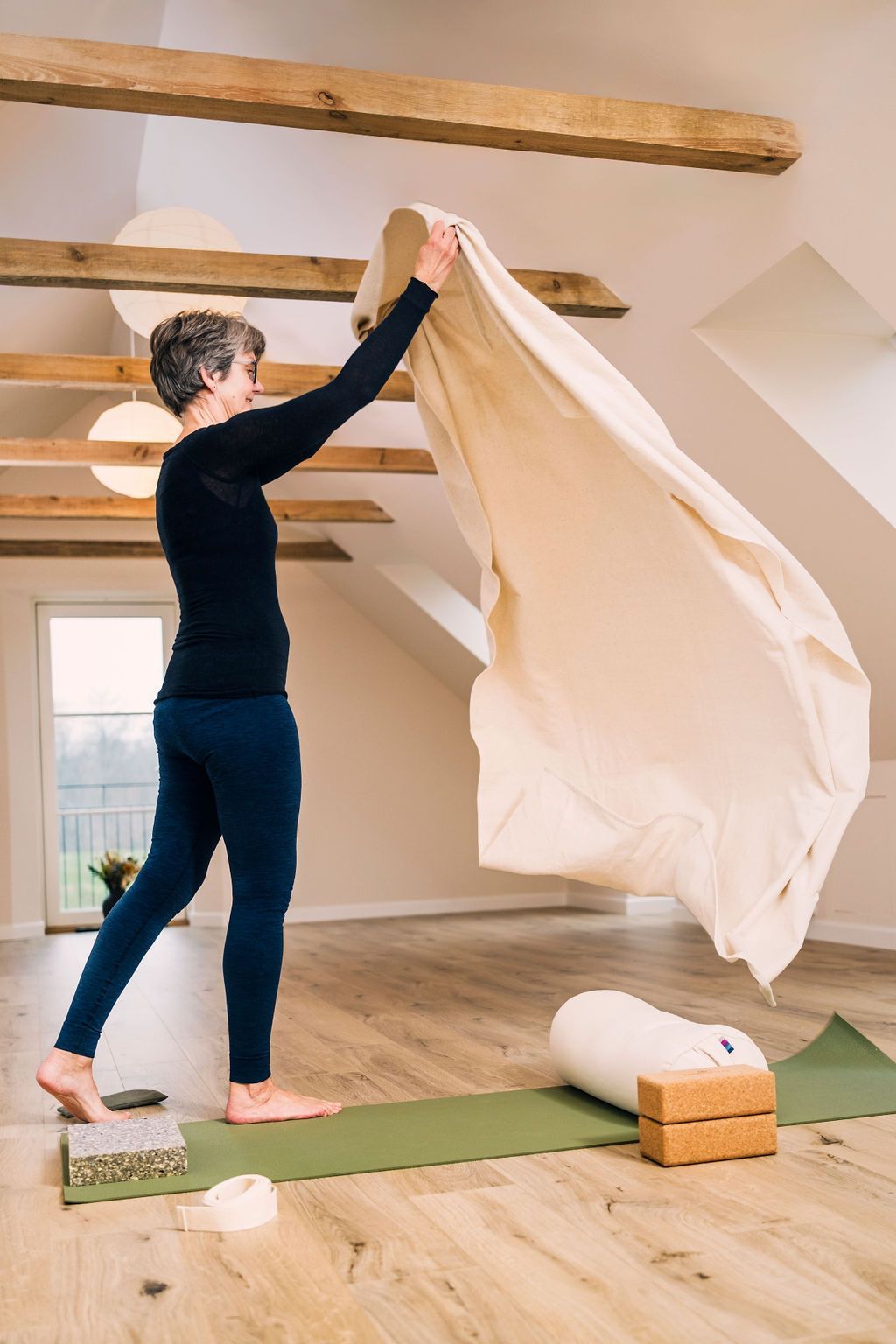En kvinde står på en yogamåtte i et yogastudio.