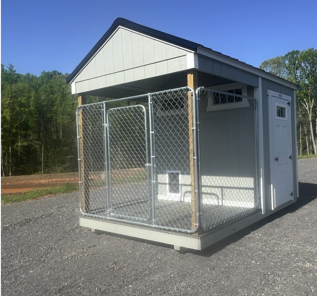 Dog kennel with a chain-link pen attached to a small shed. The shed is light blue with a white door and window