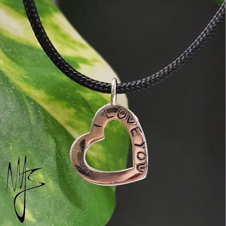 Ciondolo a forma di cuore in argento con cordino nero; testo