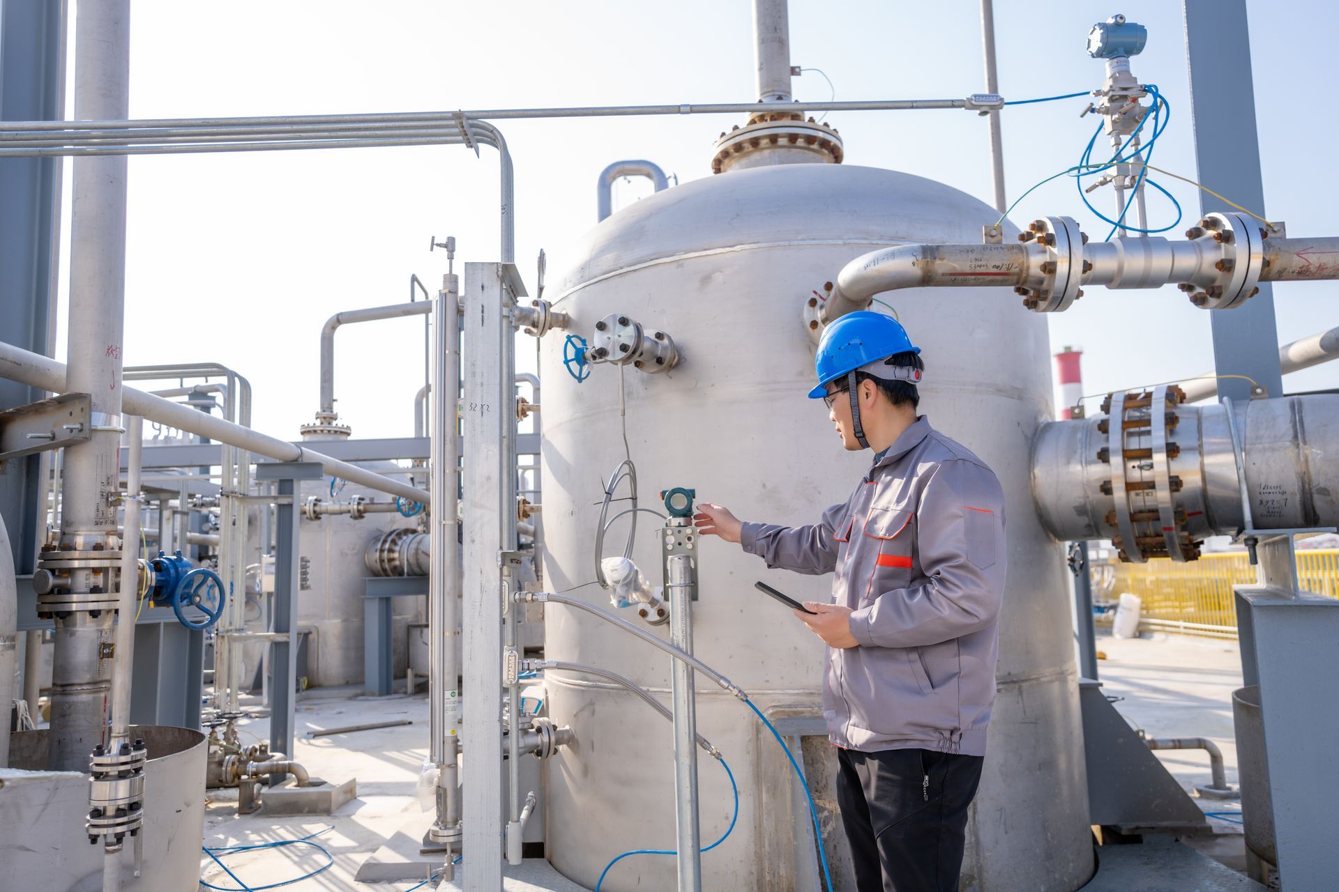 Engineer in a hard hat inspecting industrial equipment.