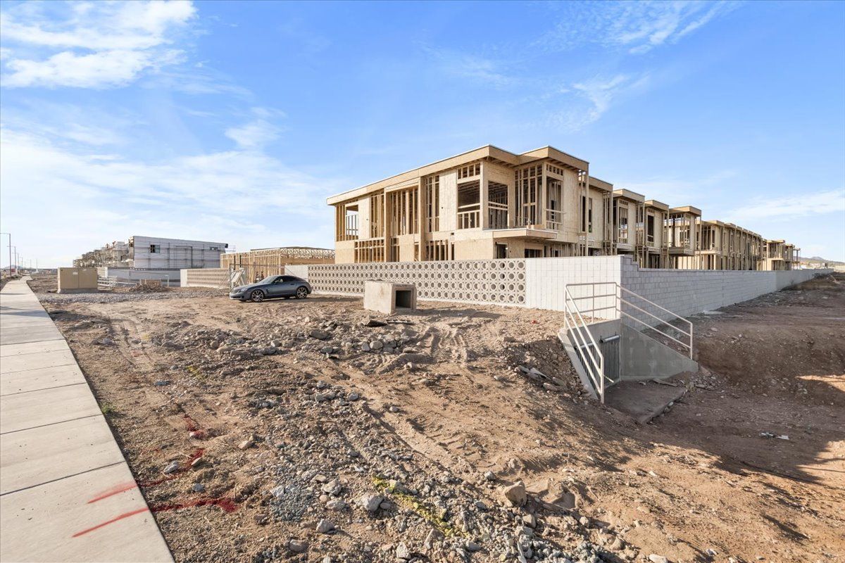 A large building is being built in the middle of a dirt field.