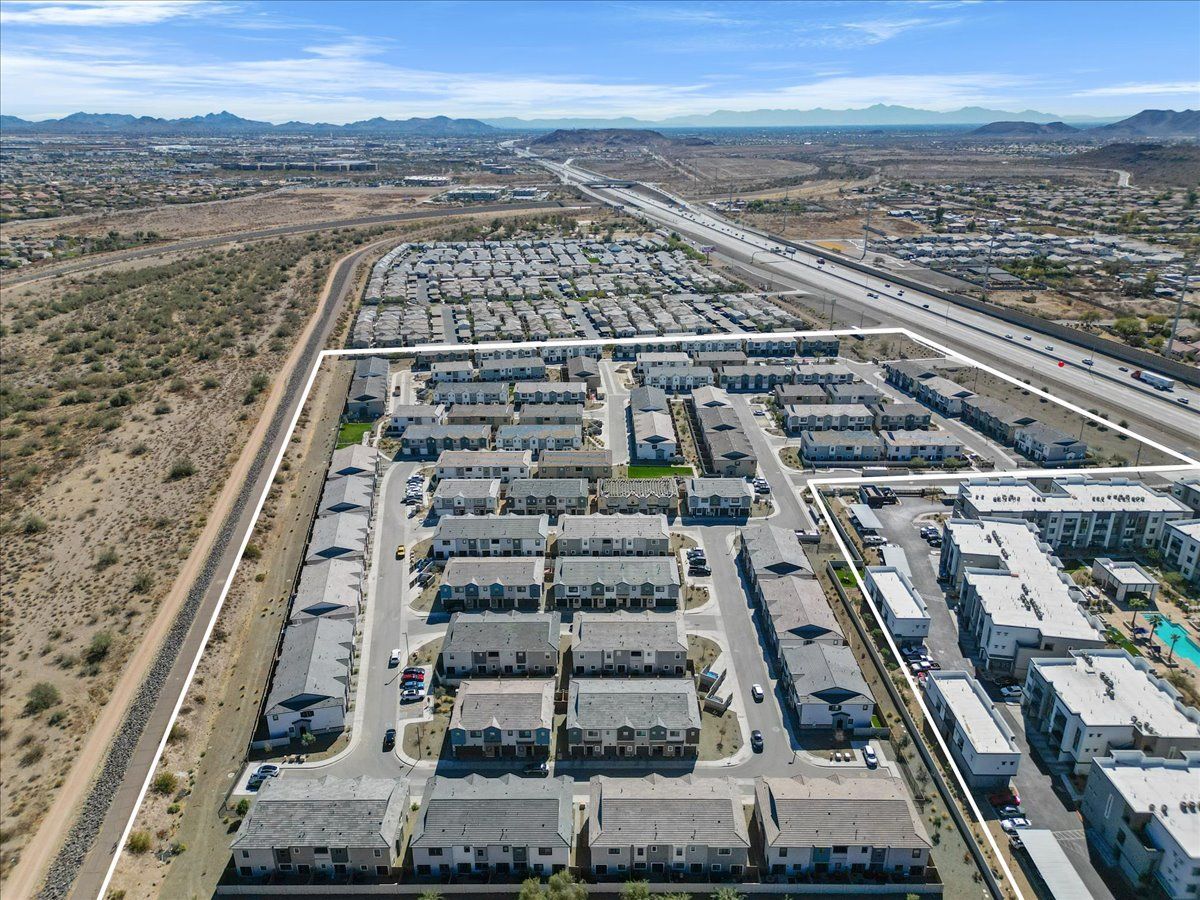 An aerial view of a residential area with a highway in the background.