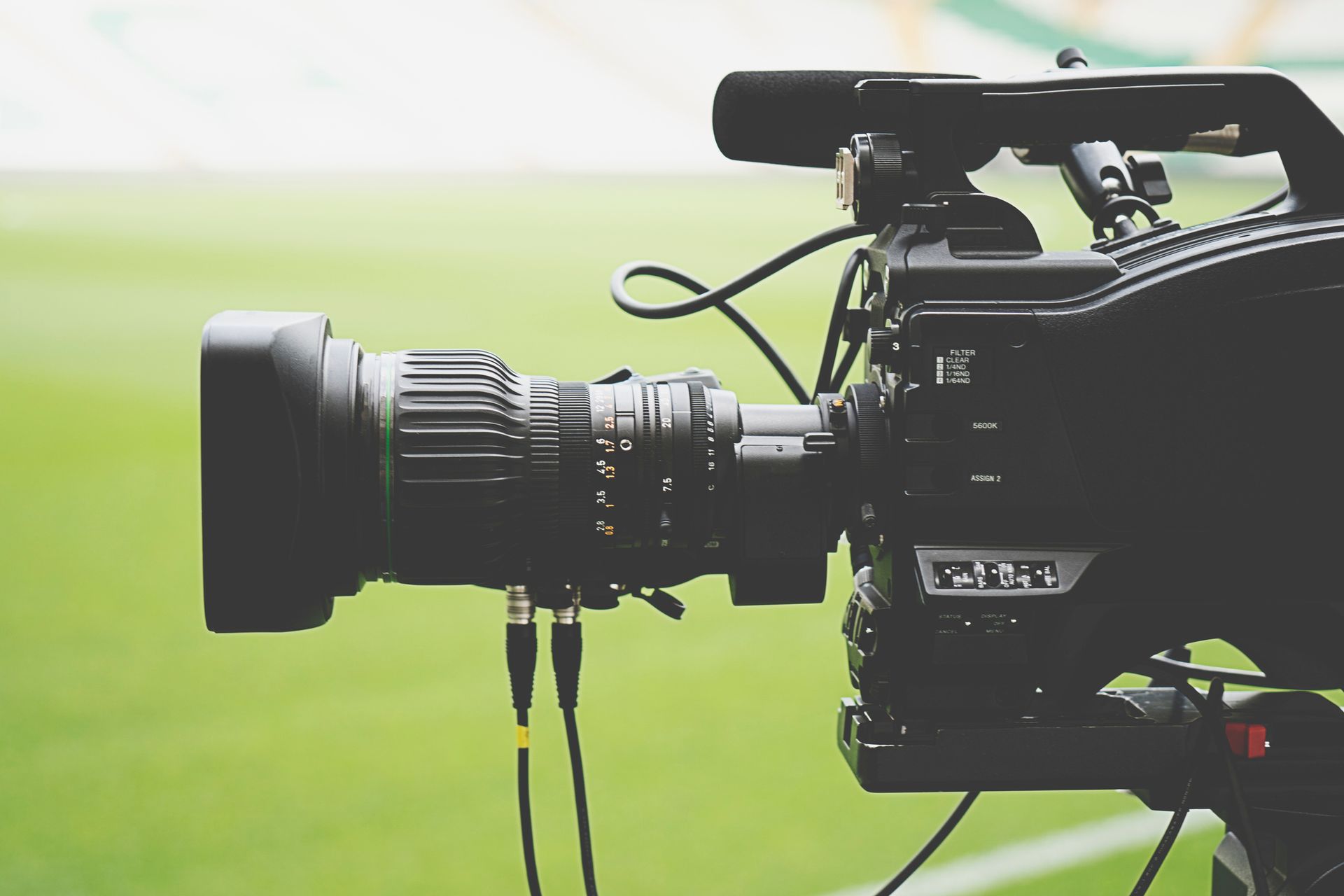 A close up of a video camera on a green field