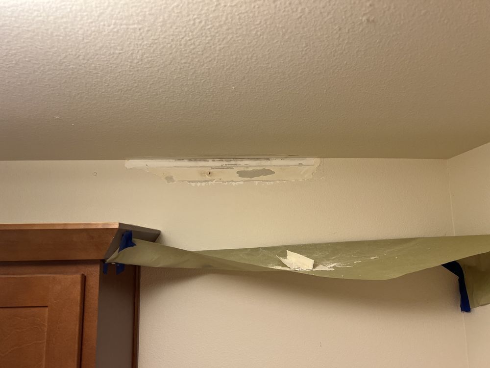 Sagging shelf mounted above a wooden cabinet with blue supports in a room