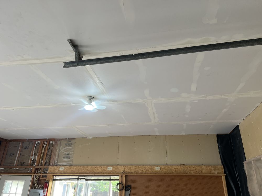 Ceiling under renovation with exposed wiring and a single light bulb in a room with unfinished walls