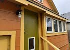 Orange building exterior with a small door and windows along a walkway