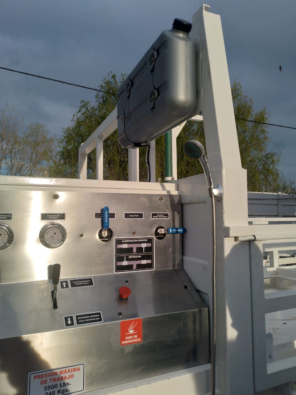 Primer plano de una máquina industrial blanca con indicadores, controles y un letrero montado en el exterior.