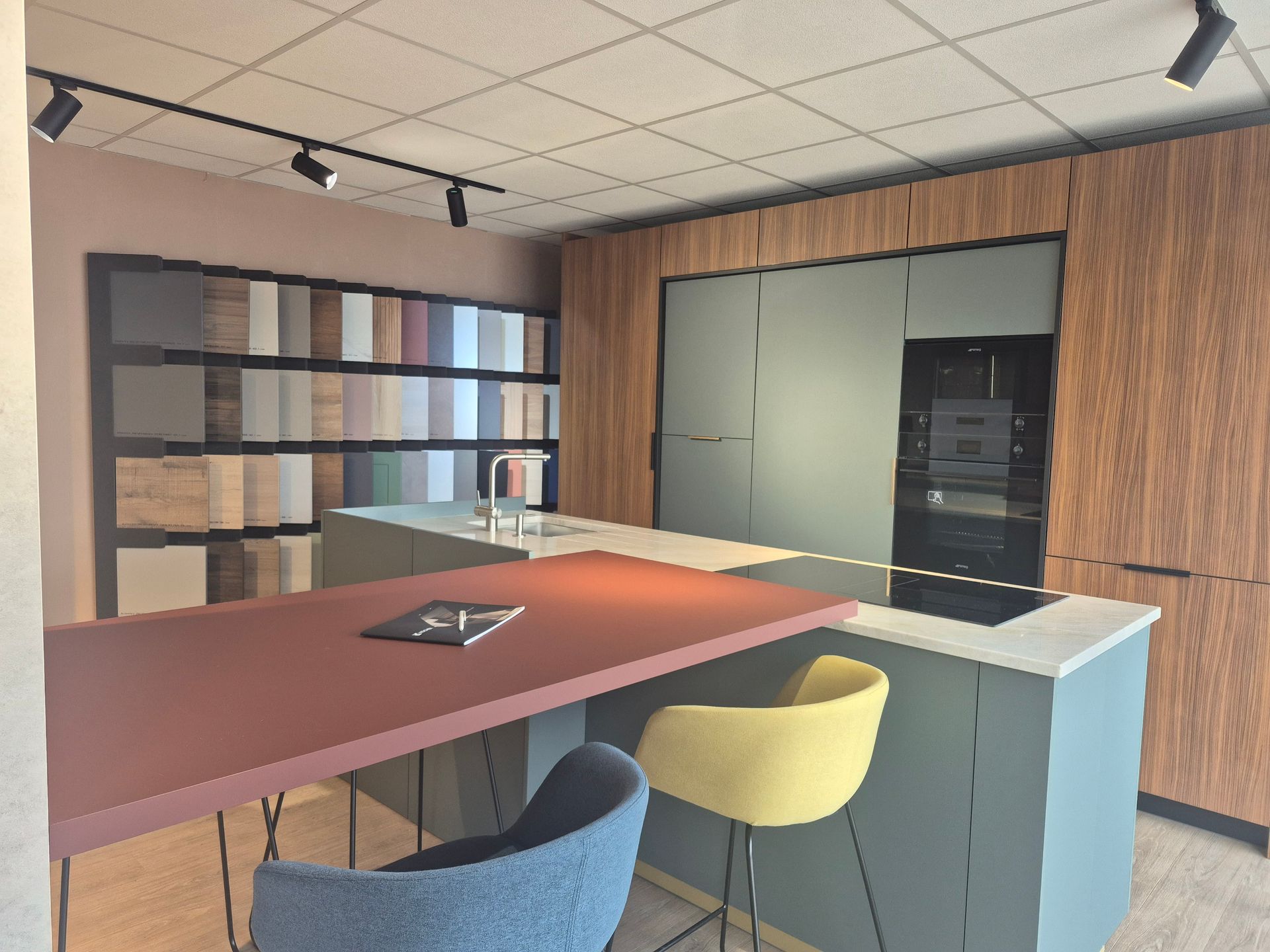 Cuisine moderne avec îlot central, tabourets de bar, fours encastrés et étagères dans un intérieur lambrissé.
