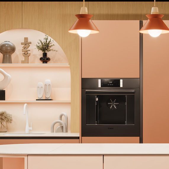 Cuisine moderne avec four encastré, étagères ouvertes, évier blanc et luminaires suspendus à l'ambiance chaleureuse.