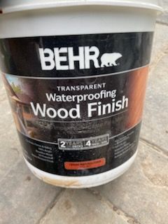 BEHR transparent waterproofing wood finish bucket on a concrete floor