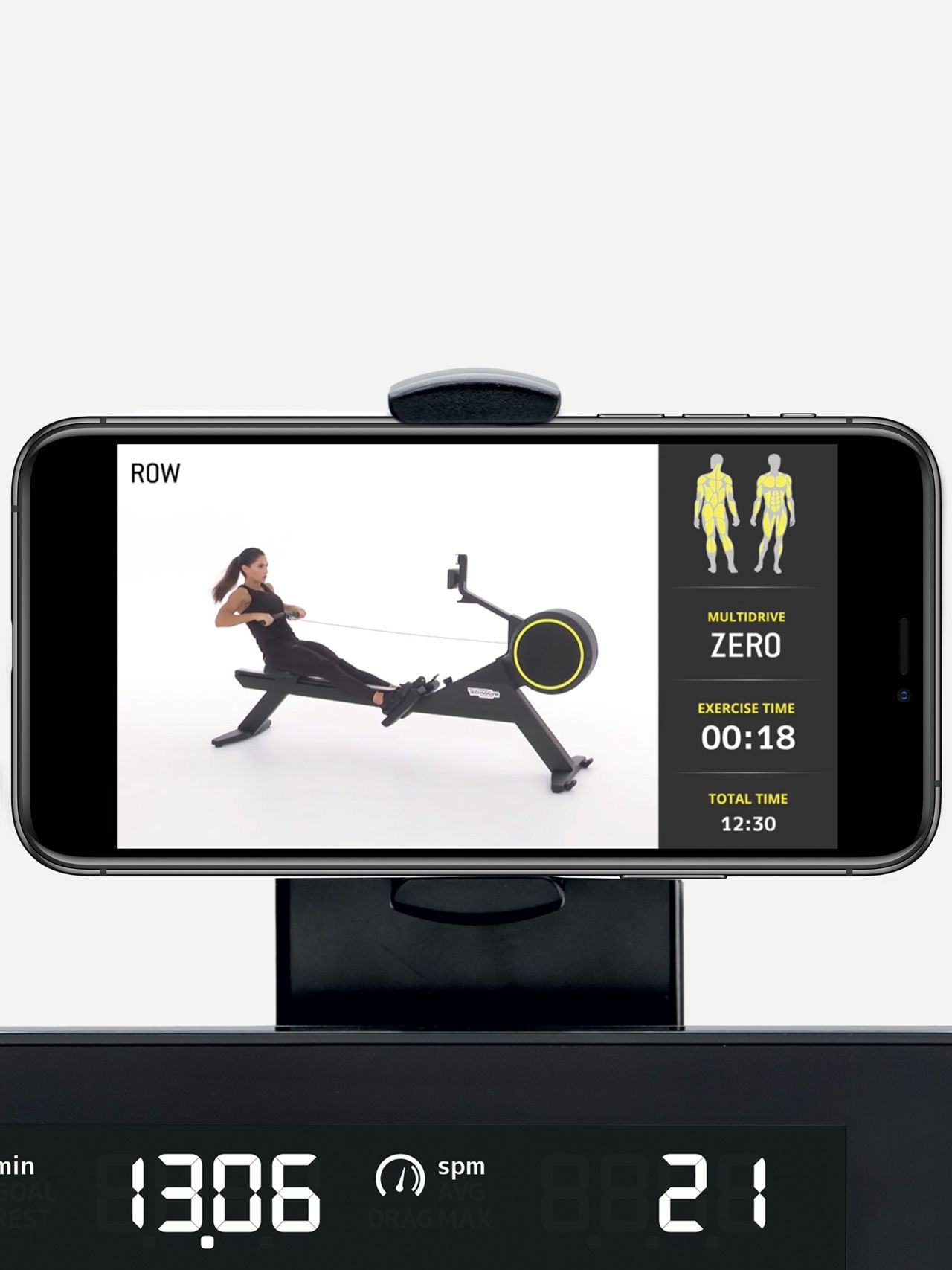 A smartphone on a row machine holder displays a rowing workout app, with performance metrics visible on the rower console.