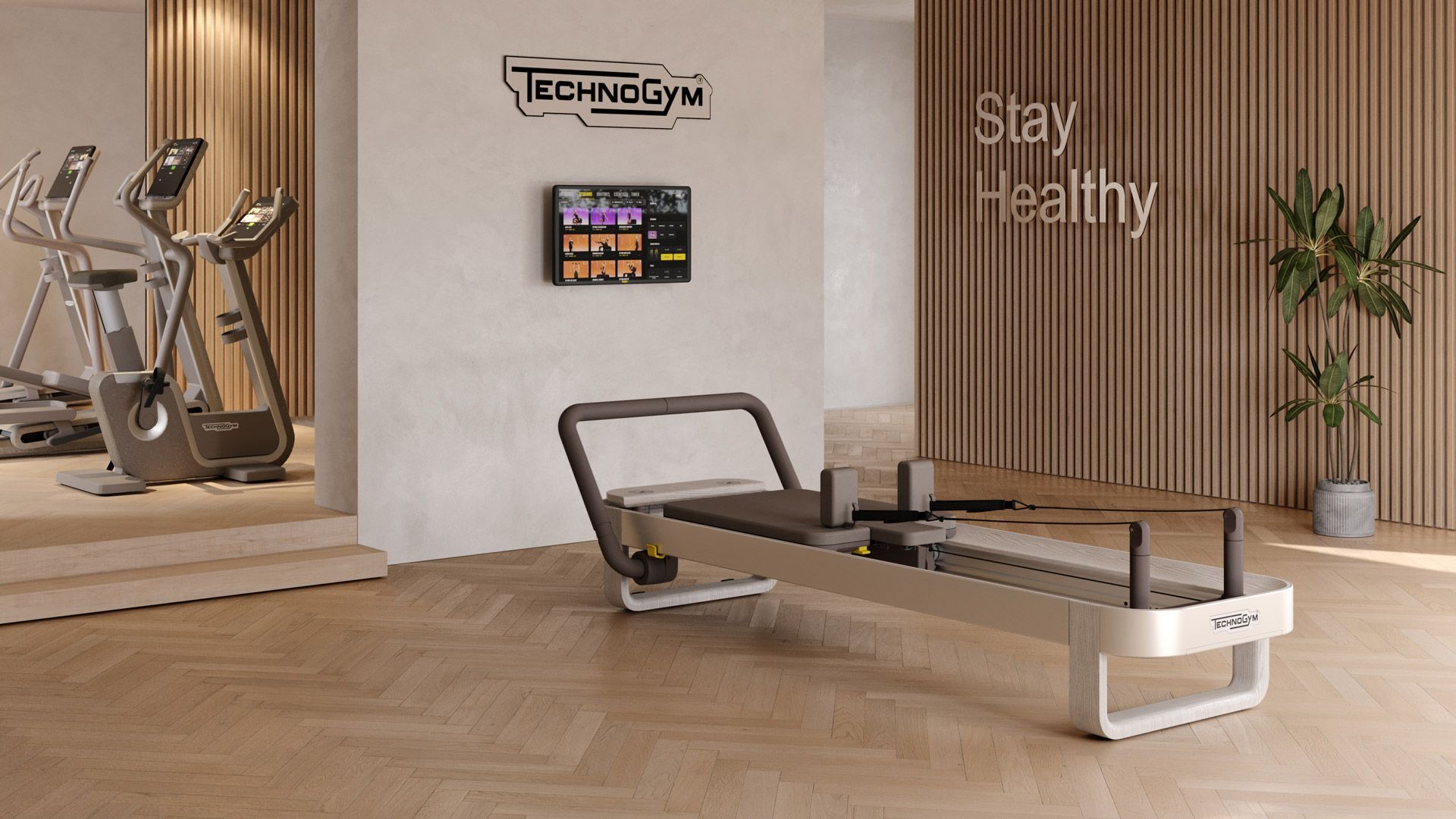 A modern fitness room with a Technogym Pilates reformer in the foreground, exercise bikes in the back, and wooden walls.