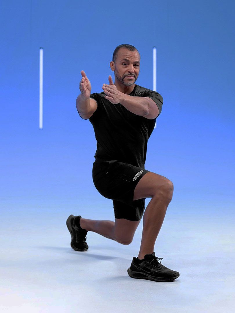 A person in athletic wear performs a lunge against a blue background, extending arms forward with palms facing each other.