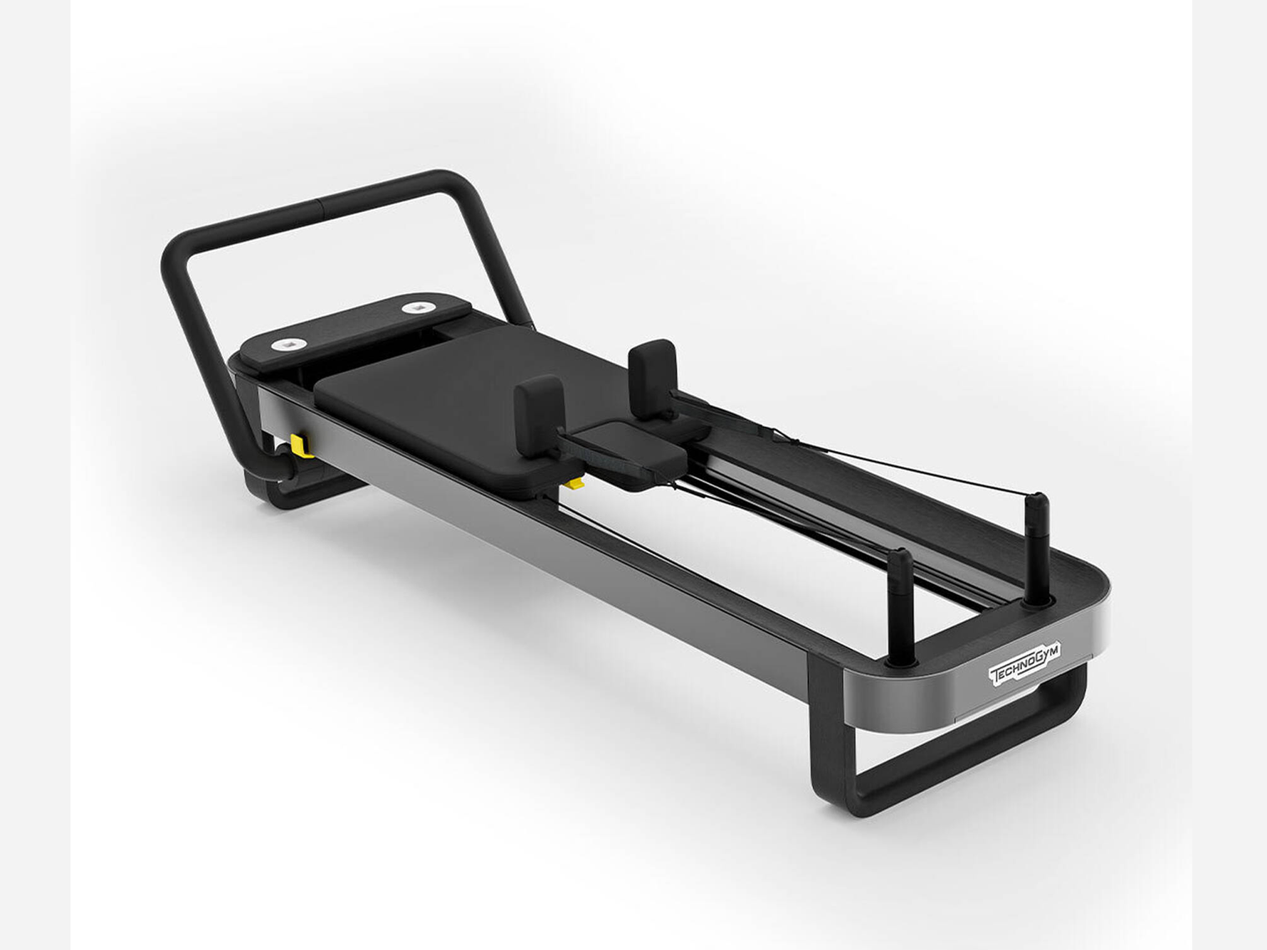 A sleek, dark gray Pilates reformer machine with a black padded sliding carriage, shoulder rests, and a foot bar.