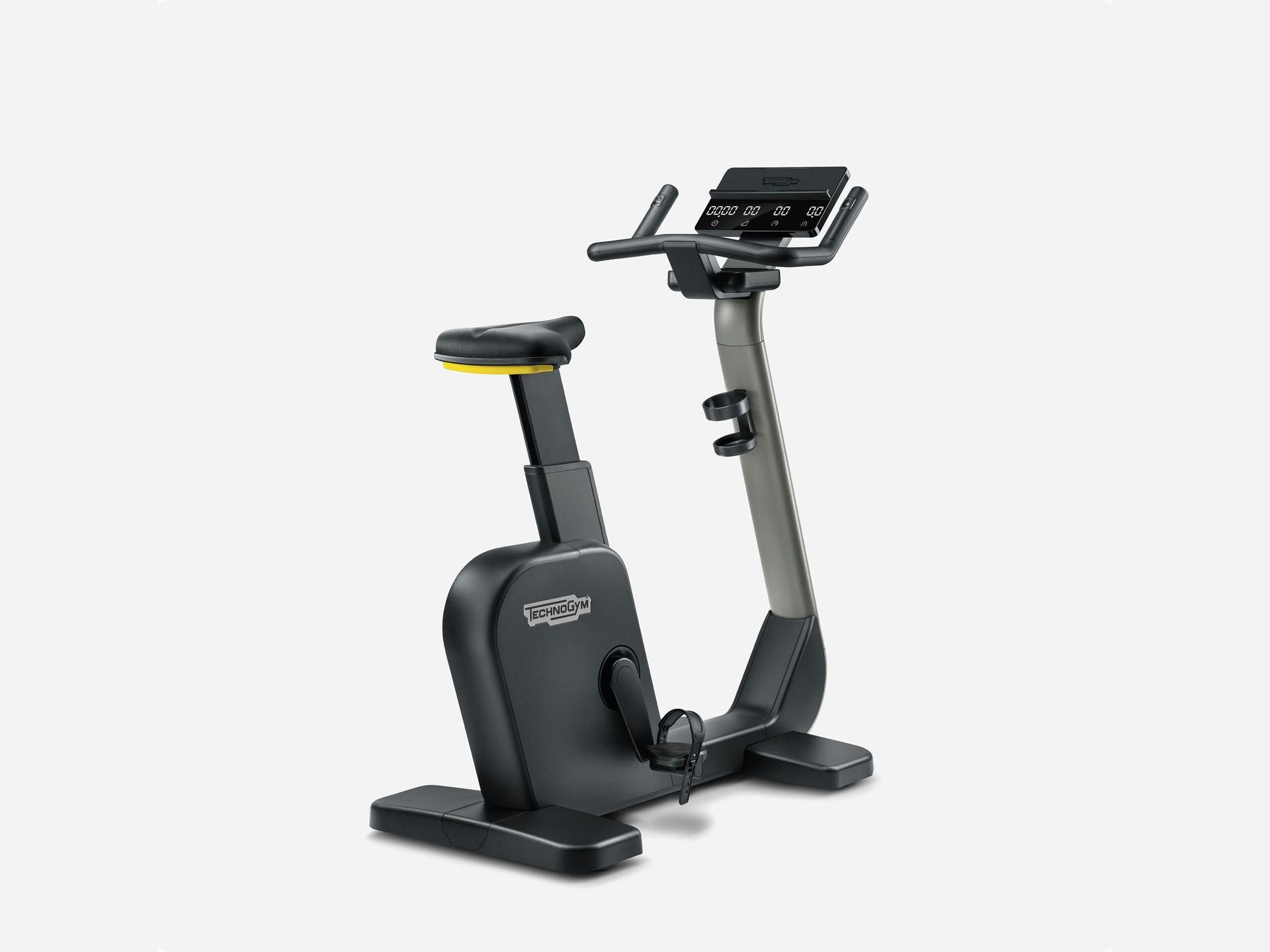 A Technogym black indoor stationary exercise bike with a digital console, viewed from a side angle against a white background.