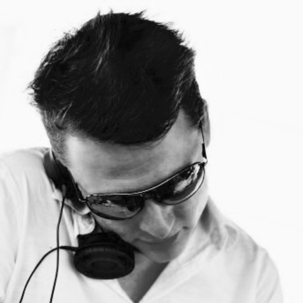 A man wearing headphones and sunglasses looks down