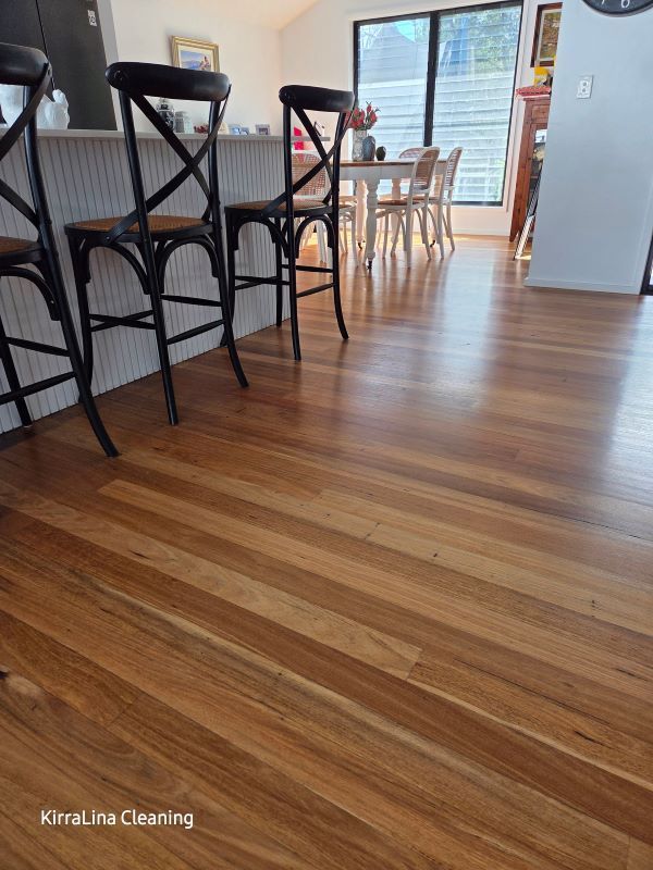 Wooden Floors and Bar Stools in A Kitchen with A Dining Table Visible in The Background — KirraLina Cleaning Services in Tweed Heads, NSW