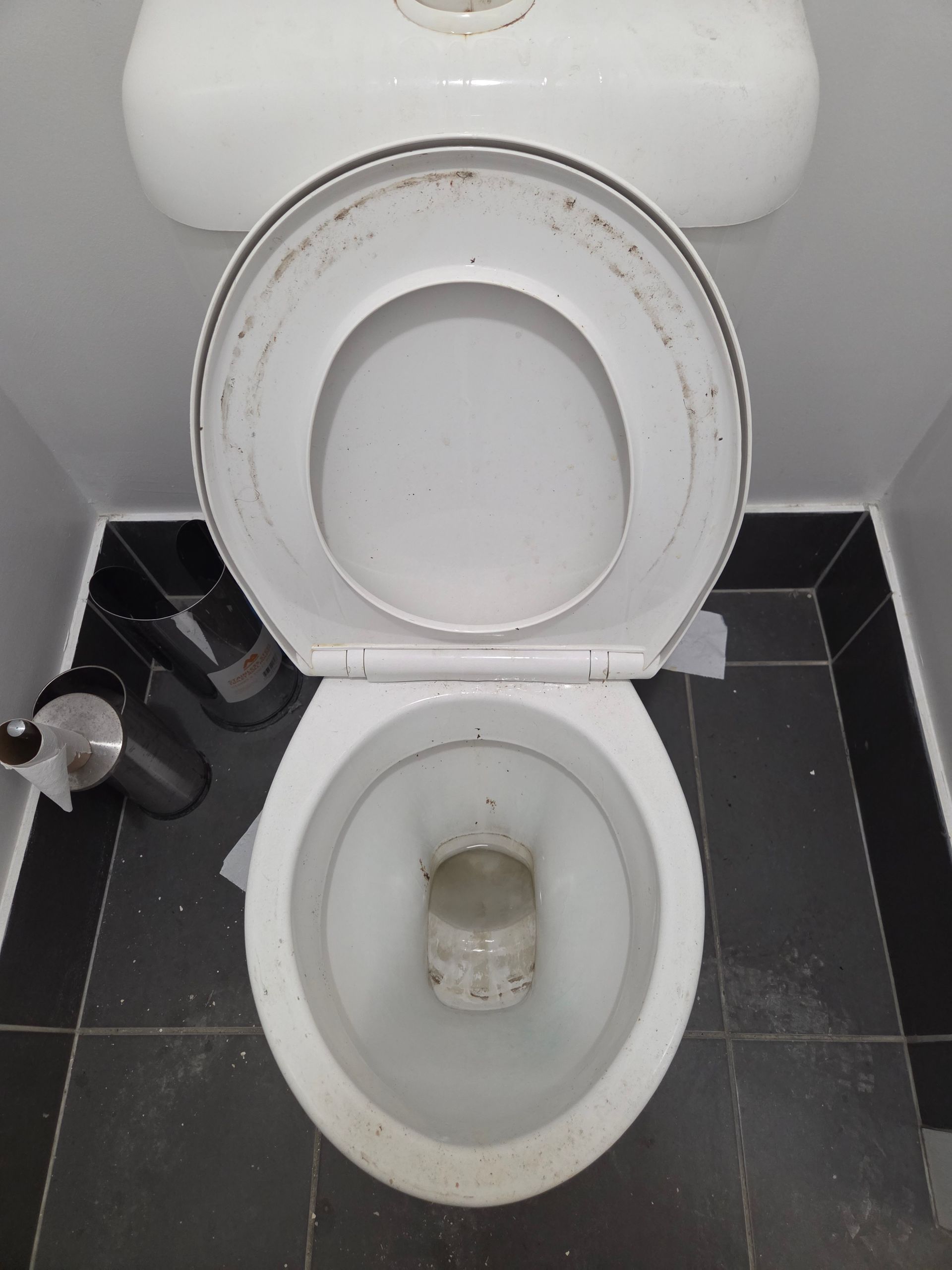 Top Down View of A Dirty White Toilet in A Small Tiled Bathroom — KirraLina Cleaning Services in Tweed Heads, NSW