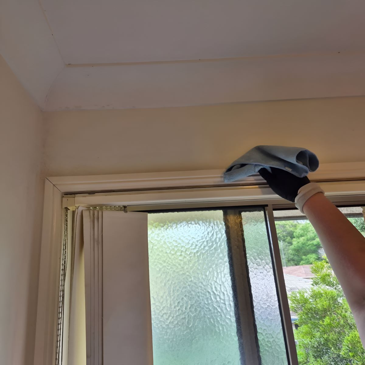 A Person Is Cleaning a Window with A Cloth — KirraLina Cleaning Services in Gold Coast, QLD
